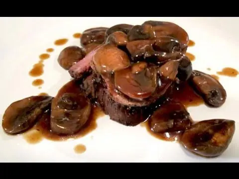 A plate of food with mushrooms and meat.