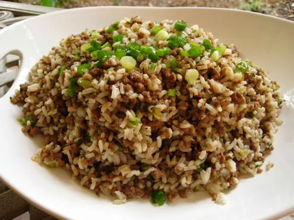 A bowl of rice and green onions on top.