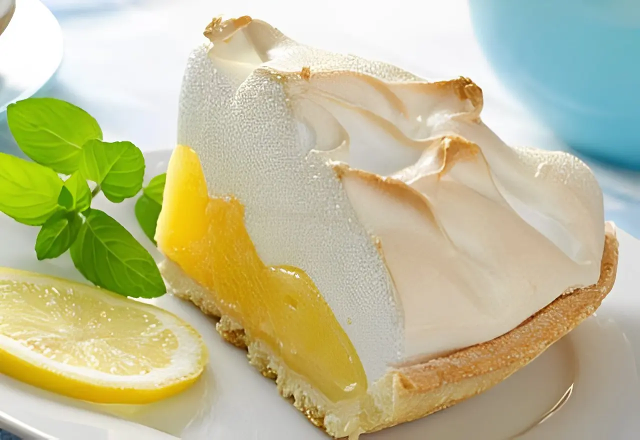 A lemon meringue pie with a slice cut out of it.