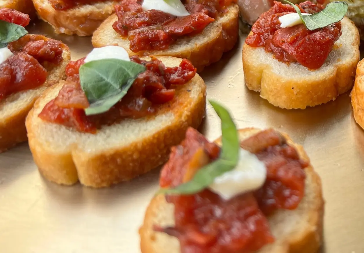 A close up of some bruschetta with basil leaves