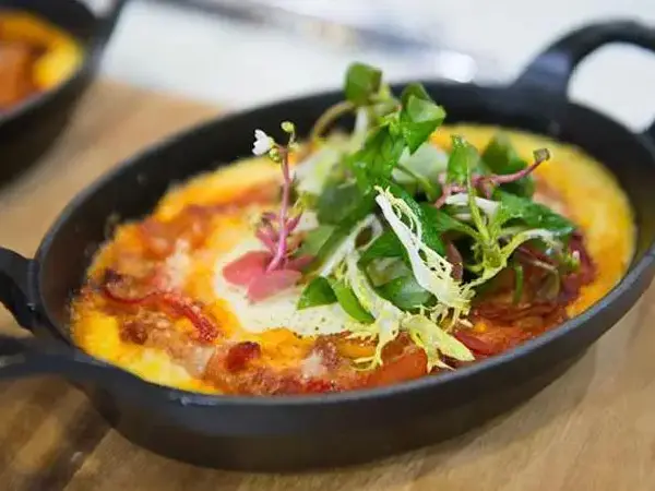 A pan of food with some vegetables on top