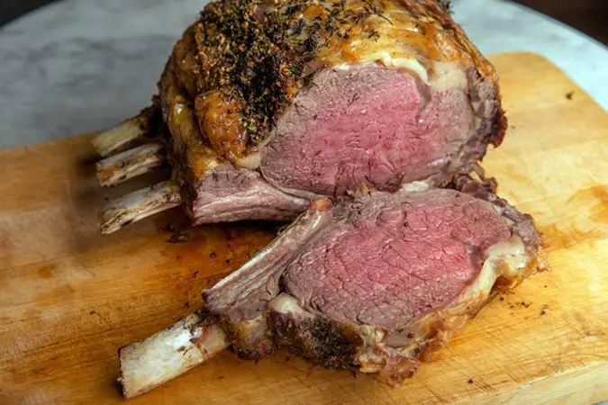 A large meat cut in half on top of a cutting board.