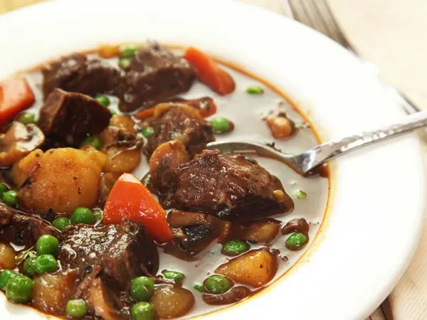 A bowl of stew with meat and vegetables.