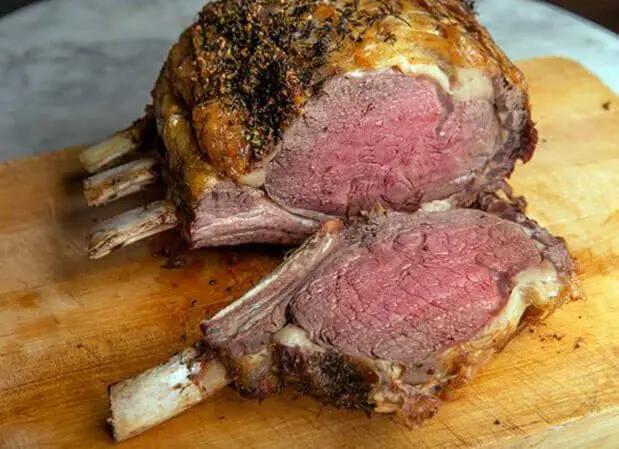 A large meat cut in half on top of a cutting board.