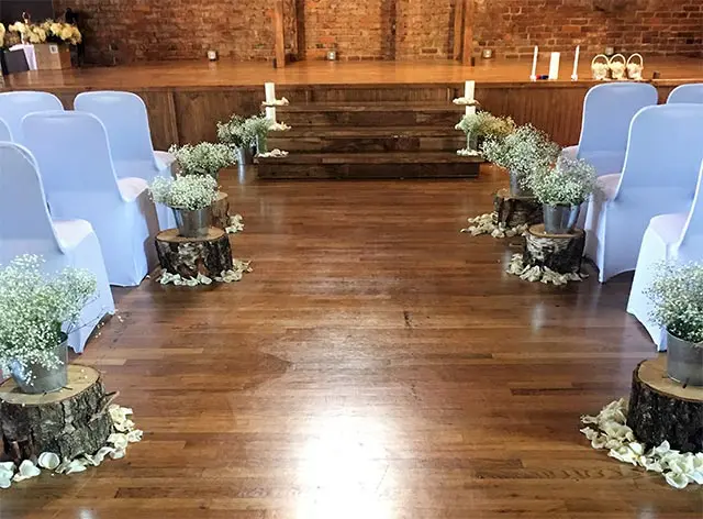 A wooden floor with chairs and flowers in the middle of it