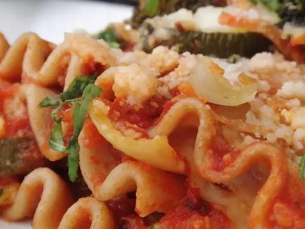 A close up of pasta with sauce and vegetables